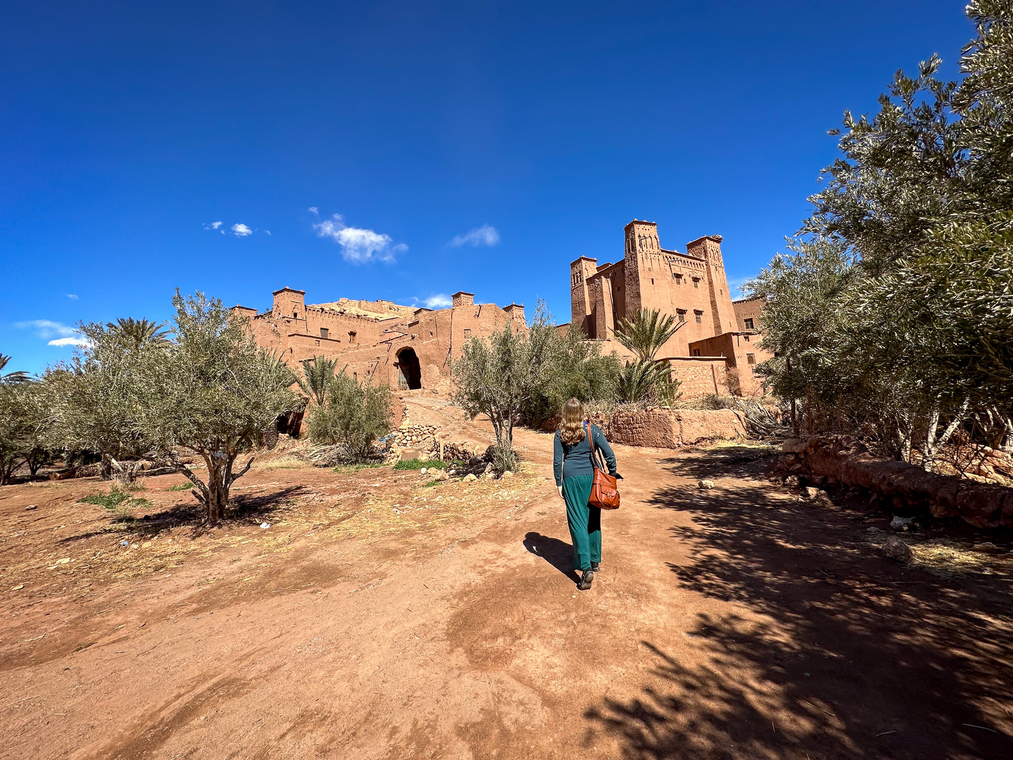 Abigail King walking towards UNESCO World Heritage Site Ait Benhaddou from the river in Morocco